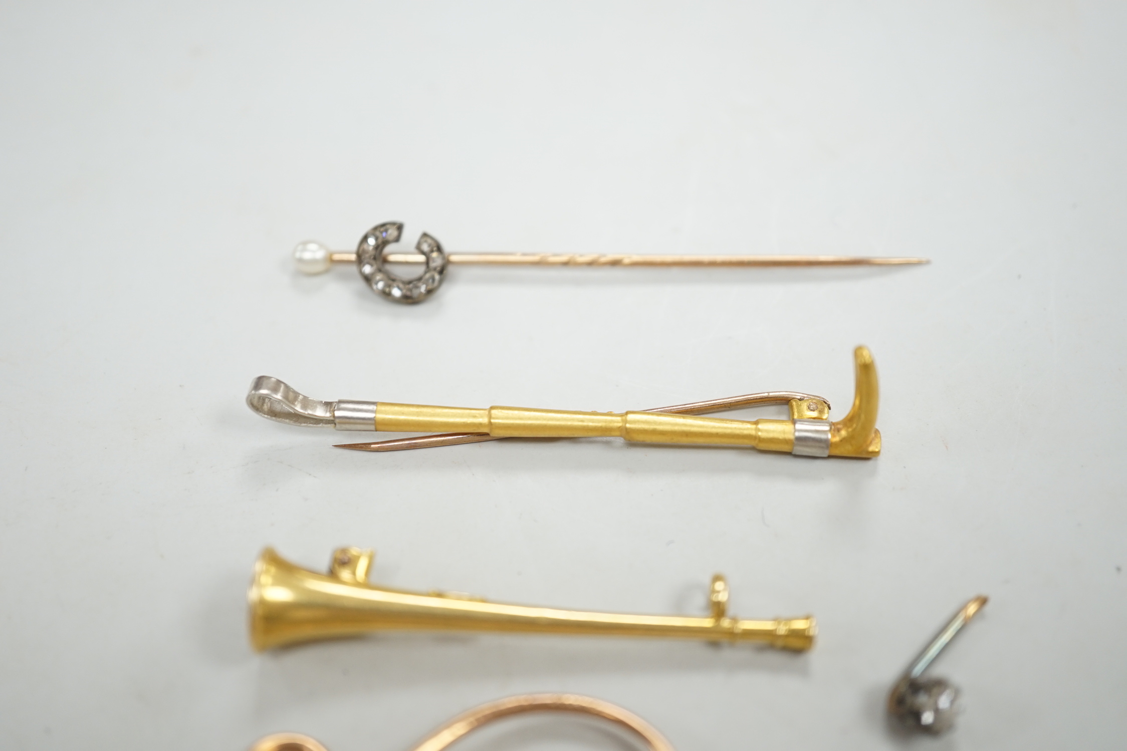 An Edwardian 15ct riding crop brooch(a.f.), 59mm, 2.8 grams, an 18ct hunting horn brooch (lacking pin) 2.1 grams, two Victorian diamond cluster set stick pins including swan in flight, a diamond set pin terminal, gross 4